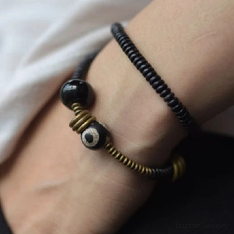 Dzi bead protective amulet bracelet featuring black onyx and natural wood beads
