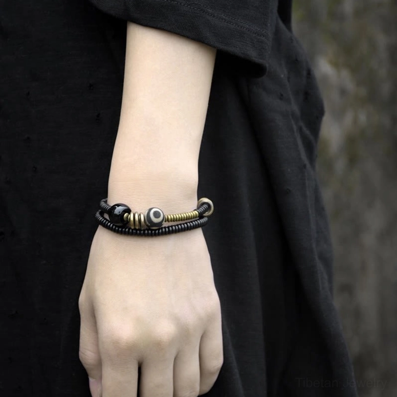 Sacred protection bracelet with Dzi bead and black onyx worn on wrist - front view