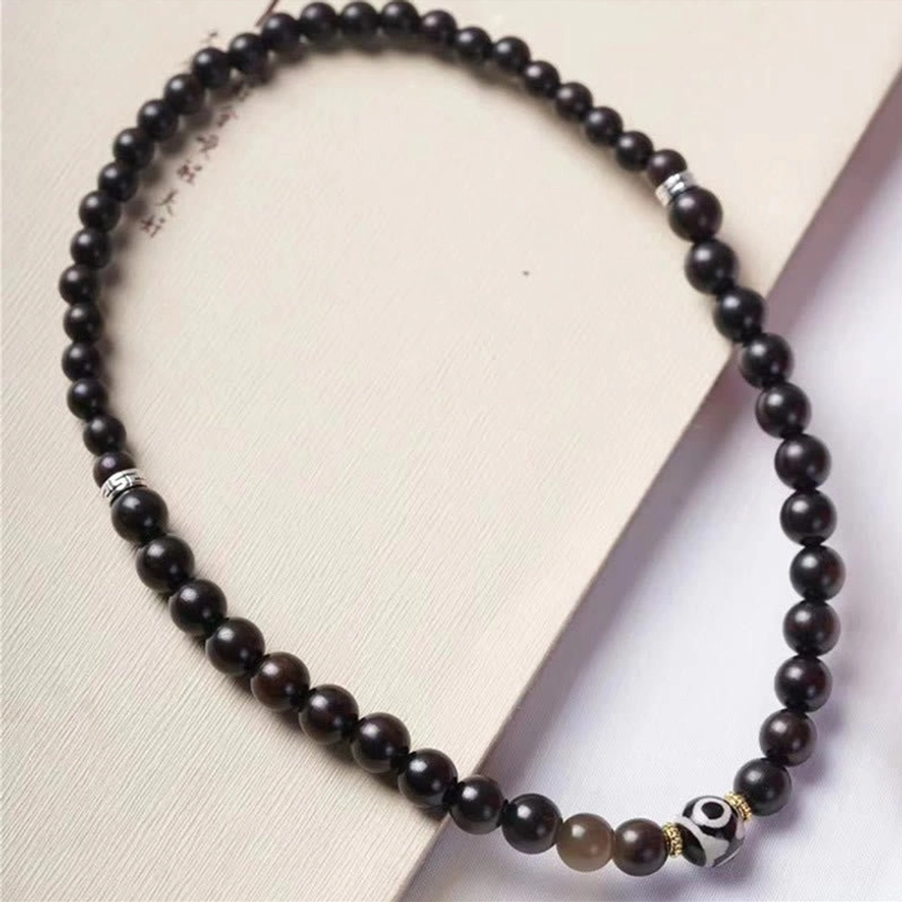 Tibetan dzi bead bracelet extended in line, studio product display showing full length with silver spacers and decorative dzi bead