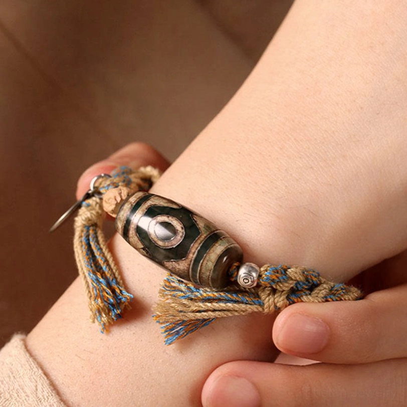 Woman wearing adjustable Tibetan Dzi bead bracelet on wrist showing how to wear the sacred protection amulet for daily spiritual practice