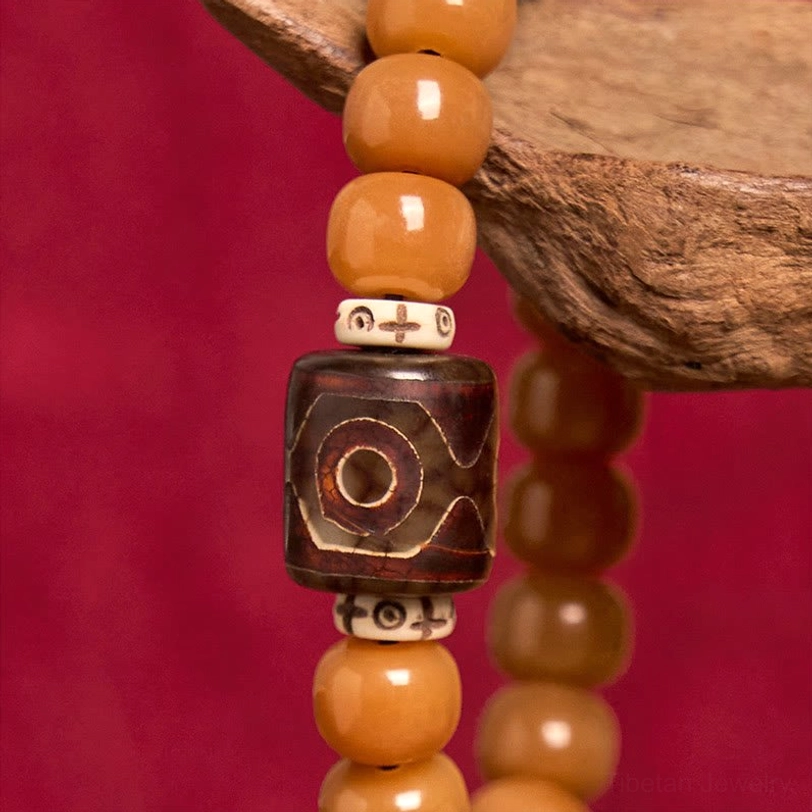 Close-up Dzi bead pattern detail - hand-painted protective amulet bead with white spacer rings and intricate design