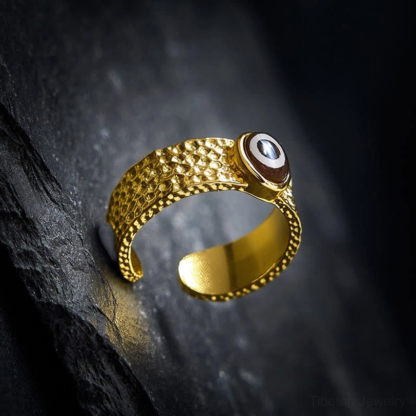 Side profile of adjustable Dzi bead copper ring showing open band and bead attachment