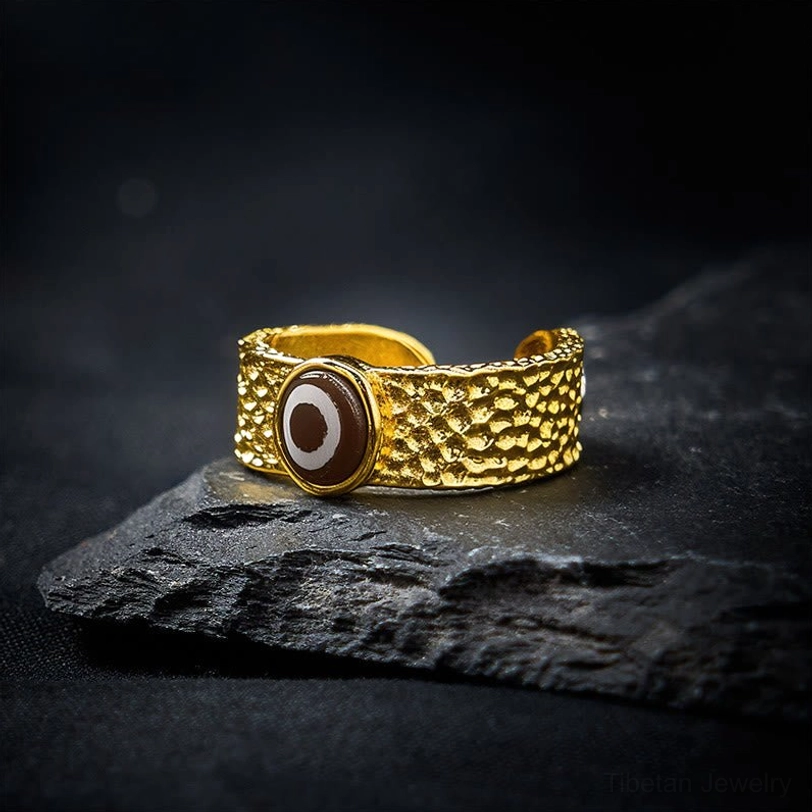 Tibetan Dzi bead copper ring tilted angle showing evil eye symbol and hammered metal finish