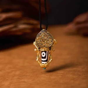 Hand-painted Dzi bead pendant necklace with carved gold filigree mount and blue stone detail, direct front view