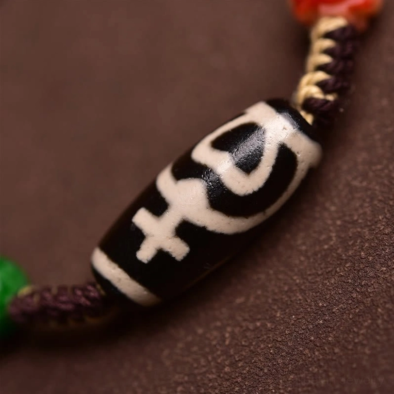 Close-up macro detail of authentic Tibetan dzi bead showing black and white sacred geometric pattern