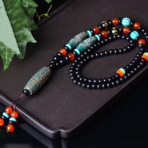 Tibetan Dzi Bead Protection Necklace overhead angled view showing etched dragon patterns and sacred beads