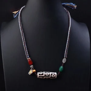 Nine-eye dzi bead protection necklace displayed on mannequin showing pendant positioning and adjustable cord