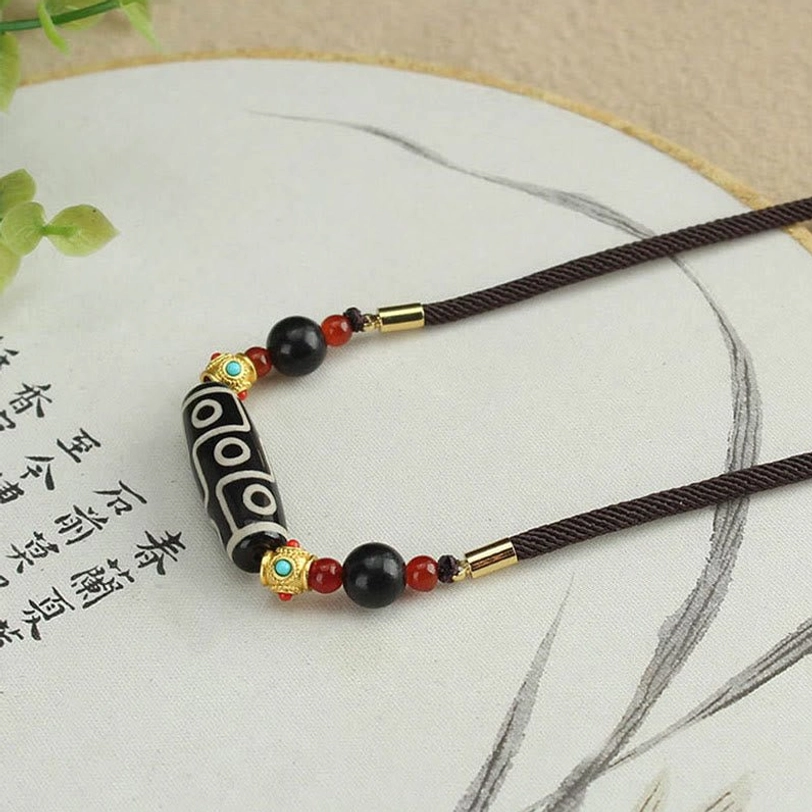 Tibetan ethnic dzi bead necklace with traditional beaded decorations on calligraphy paper