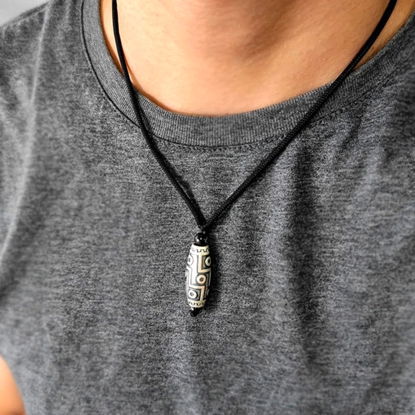 Tibetan nine-eye dzi bead necklace worn casually on grey crewneck shirt for daily styling inspiration