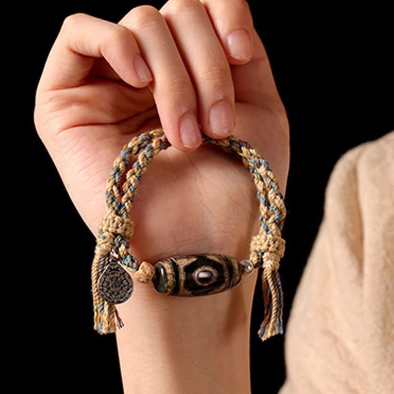 Tibetan nine-eye Dzi bead bracelet with adjustable braided string showing multiple angles of protection amulet design