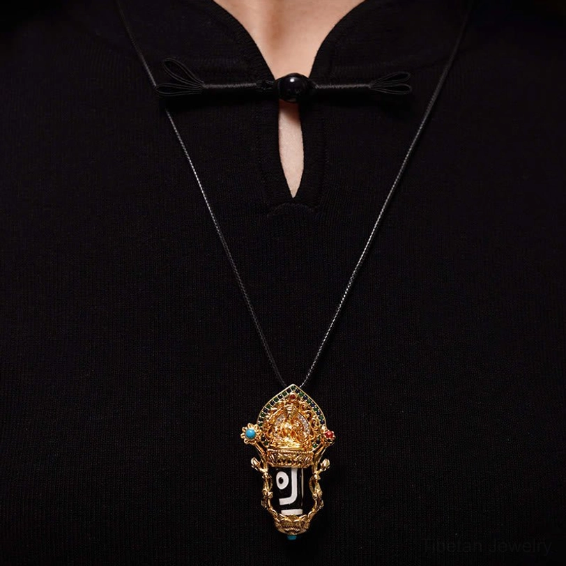 Wearable Dzi bead pendant necklace with gold setting and single-eyed Dzi bead on black cord, on-body neck wear view