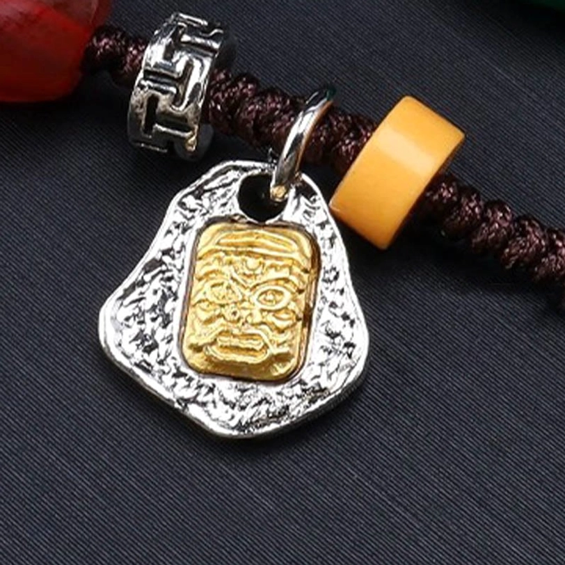 Nine-eye dzi bead necklace close-up showing silver metal work pendant and woven cord construction