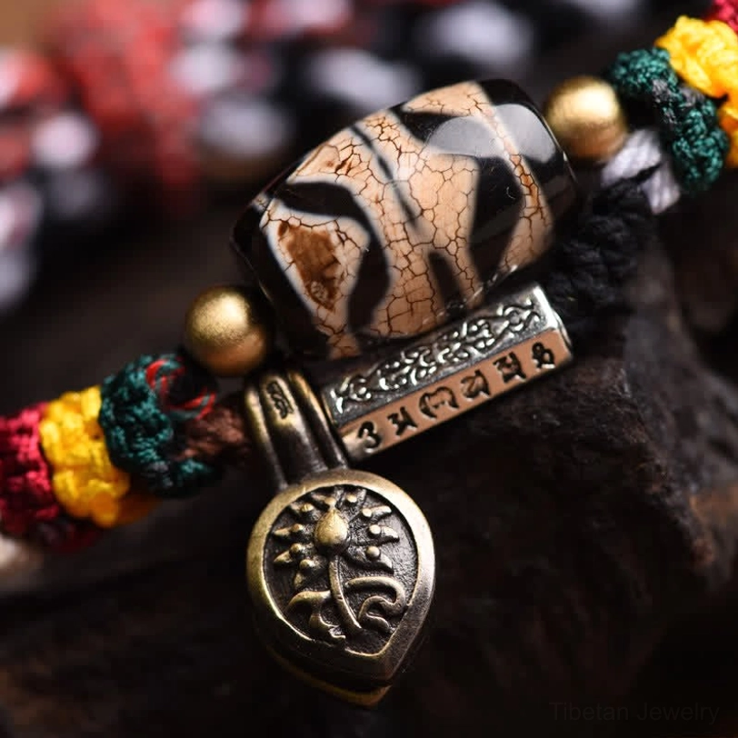 Tibetan Dzi bead Om Mani Padme Hum protective amulet bracelet featuring sacred symbolism and spiritual intention for meditation practice