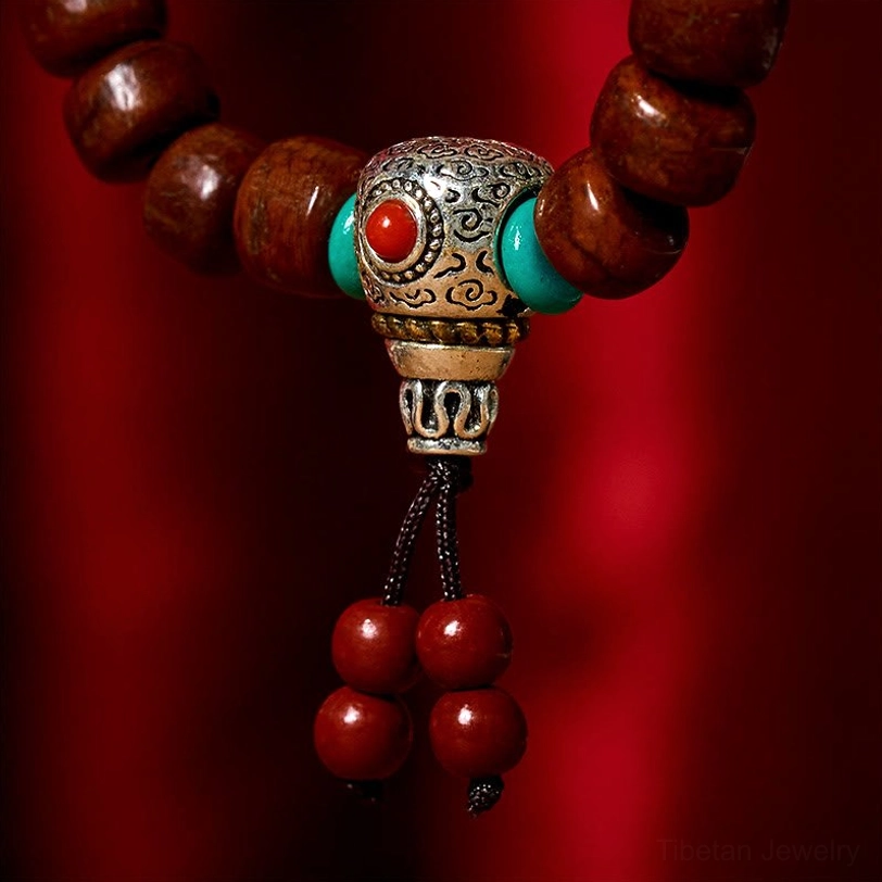 Carved silver Dzi bead accent with inlaid turquoise and red stone macro close-up shot