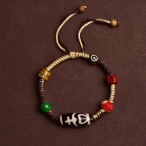Nine-eye Tibetan dzi bead bracelet flat lay overhead view showing adjustable drawstring closure and complete design