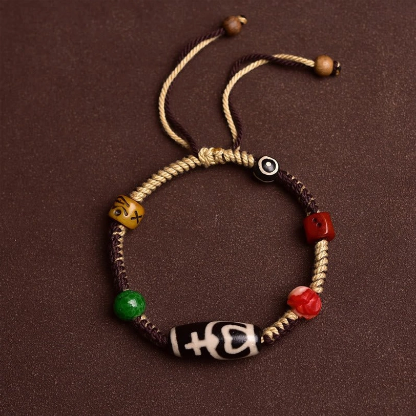 Nine-eye Tibetan dzi bead bracelet flat lay overhead view showing adjustable drawstring closure and complete design