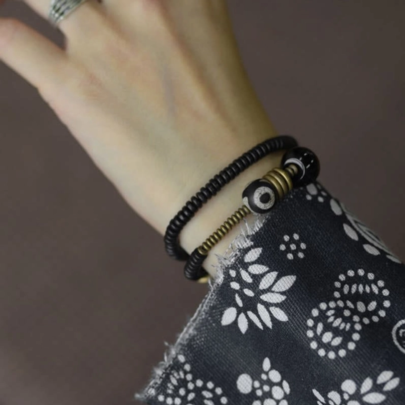 Tibetan Dzi bead bracelet with black onyx grounding stone and brass spiritual accents