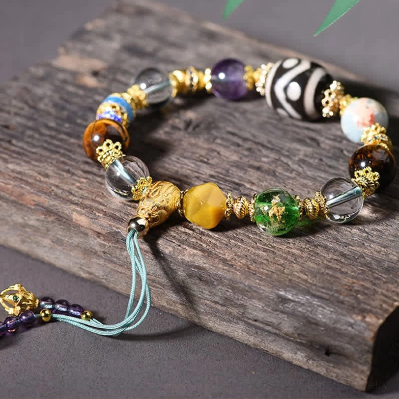 Adjustable Dzi bead bracelet side view showing blue tassel and gemstone details