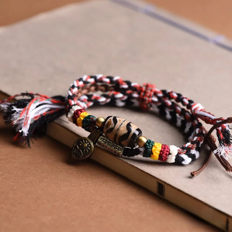 Tibetan braided Dzi bead bracelet with copper accents displayed on wrist showing adjustable fit and color symbolism