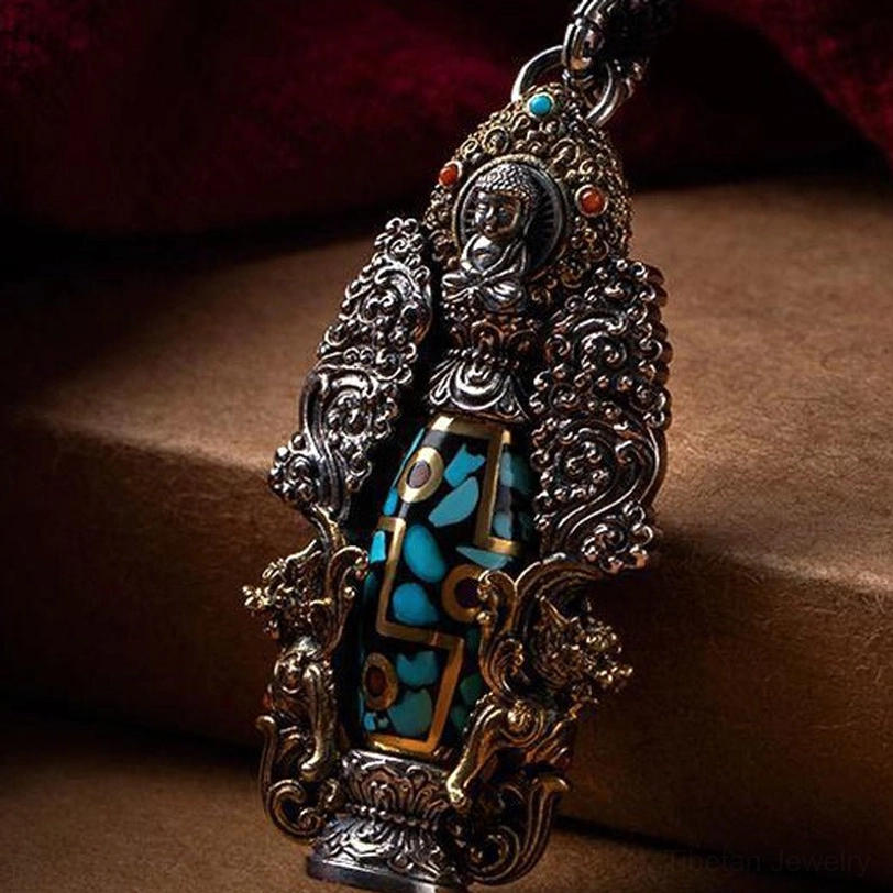 Side view of Tibetan dzi Buddha pendant featuring Buddha figurine on top, turquoise and metal inlay, and detailed hand-carved carvings