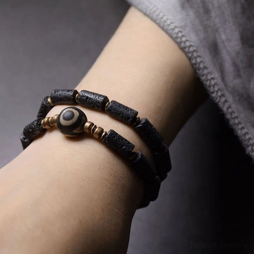 Three-eye dzi lava rock bracelet worn on wrist - double wrap design on human arm showing comfortable fit and styling