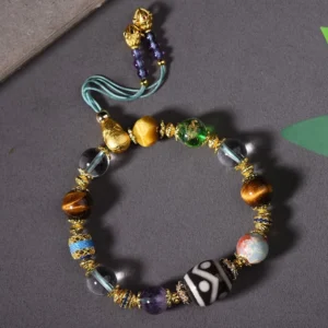 Nine-eye Dzi bead bracelet with amethyst and tiger eye stones on dark background