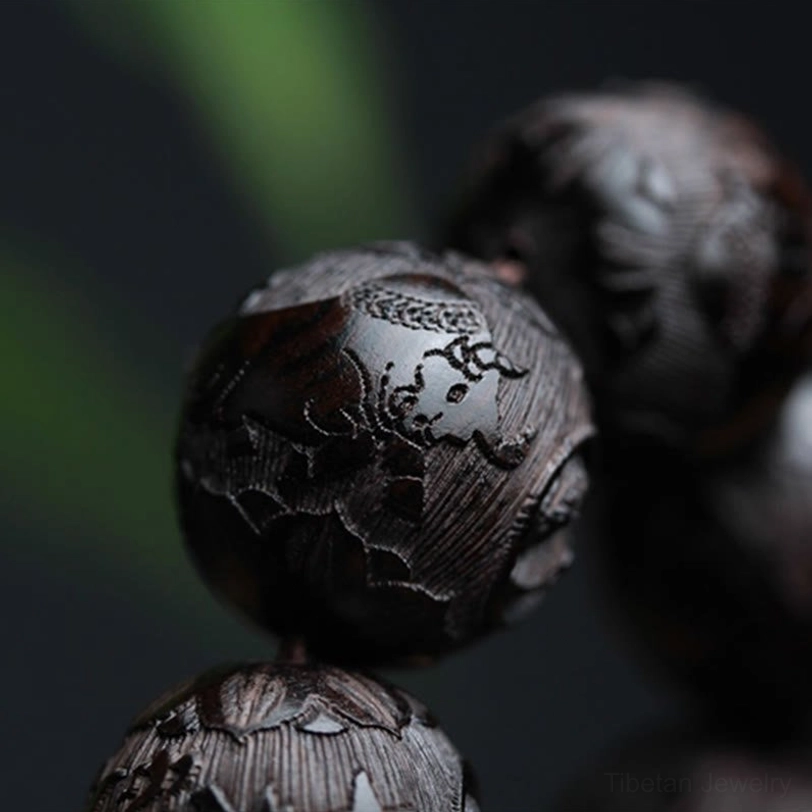 Detailed macro photography of carved ebony wood bracelet beads with fine hand-carved designs and rich wood texture