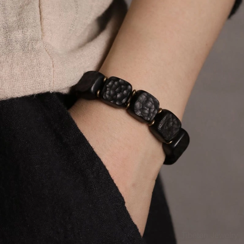 Ebony wood copper bracelet worn on wrist with casual linen clothing showing everyday spiritual jewelry styling