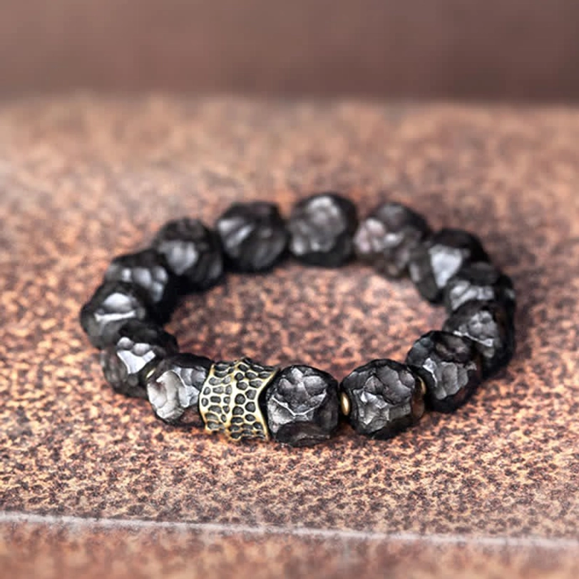 Flat lay overhead shot of ebony and copper couple bracelet with irregular faceted beads and bronze spacer on leather