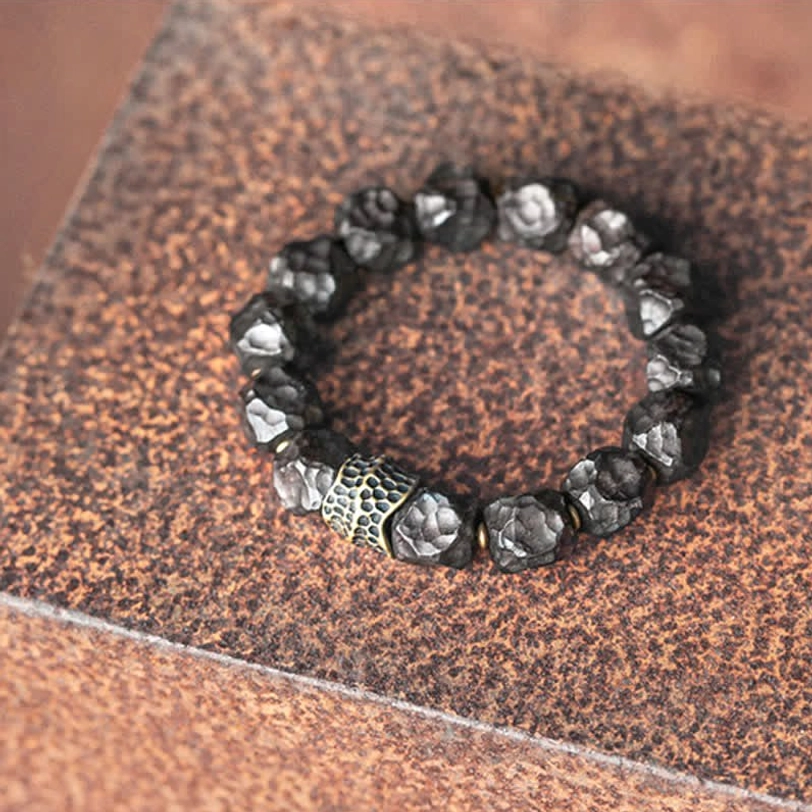 Beaded ebony and copper bracelet with varied polished dark stone beads and silver-toned patterned spacer