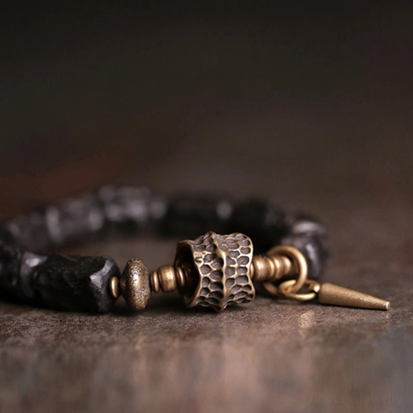 Side profile close-up of ebony wood copper bracelet showing metal connectors and textured wooden beads