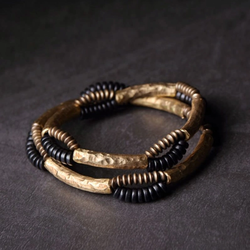 Two handmade ebony wood and copper bracelet set flat lay front view with woven bead strands