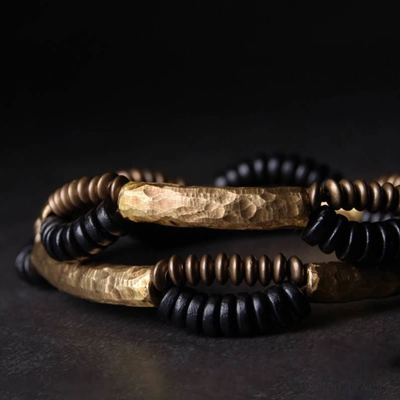 Stacked ebony wood copper bracelets overhead view showing layered design with hammered metal surfaces