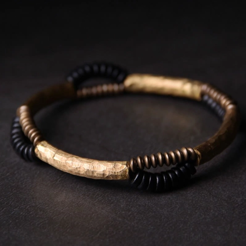 Ebony wood copper protective bracelet product shot alternating disc bead design on grey surface