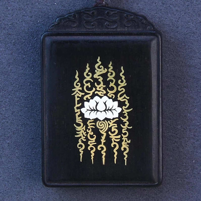 Top-down view of ebony wood lotus pendant showing carved rim and inlaid silver lotus pattern detail