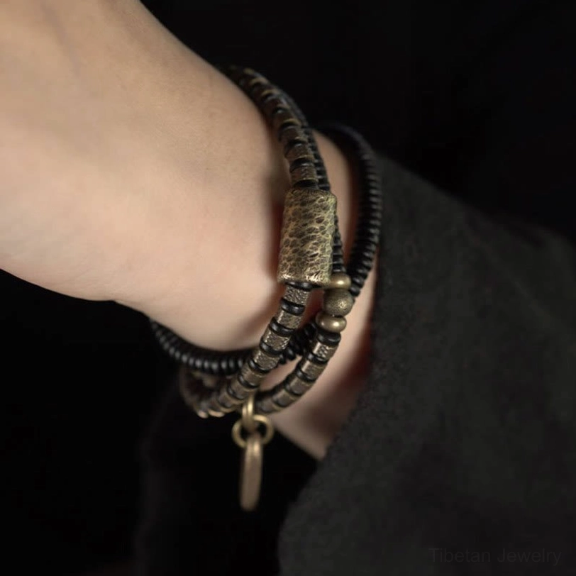Single ebony wood bracelet with large copper barrel bead on wrist