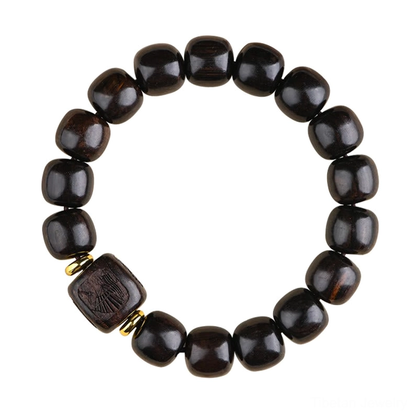 Polished ebony wood bead bracelet overhead flat lay with carved decorative accents on neutral background
