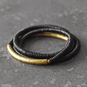 Ebony wood brass multilayered grounding bracelet flat lay top view dark stone background