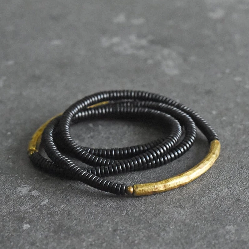 Layered ebony wood brass spiritual bracelet with gold accents flat lay