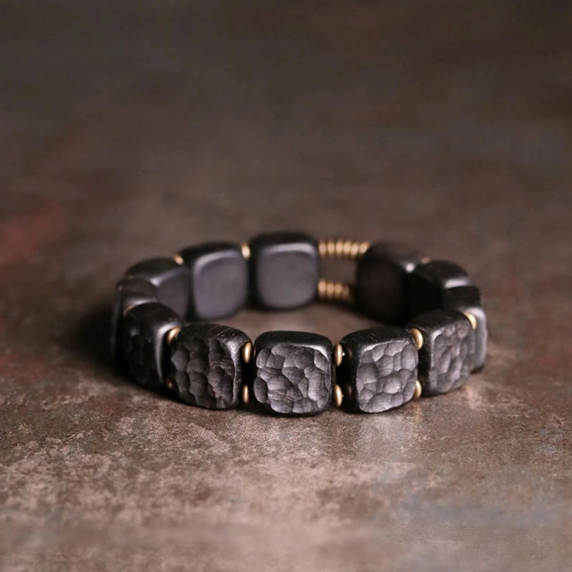 Full circular ebony wood copper balance bracelet flat lay on dark vintage tabletop with gold accents