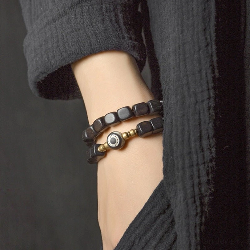 Authentic ebony wood dzi bead couple bracelet showing natural material variations and protective nine-eye dzi bead symbolism