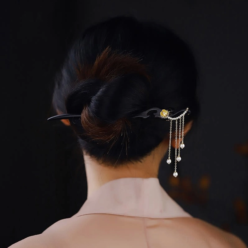 Ebony wood hairpin from back view worn on low chignon with hanging pearl tassels, demonstrating rear styling effect