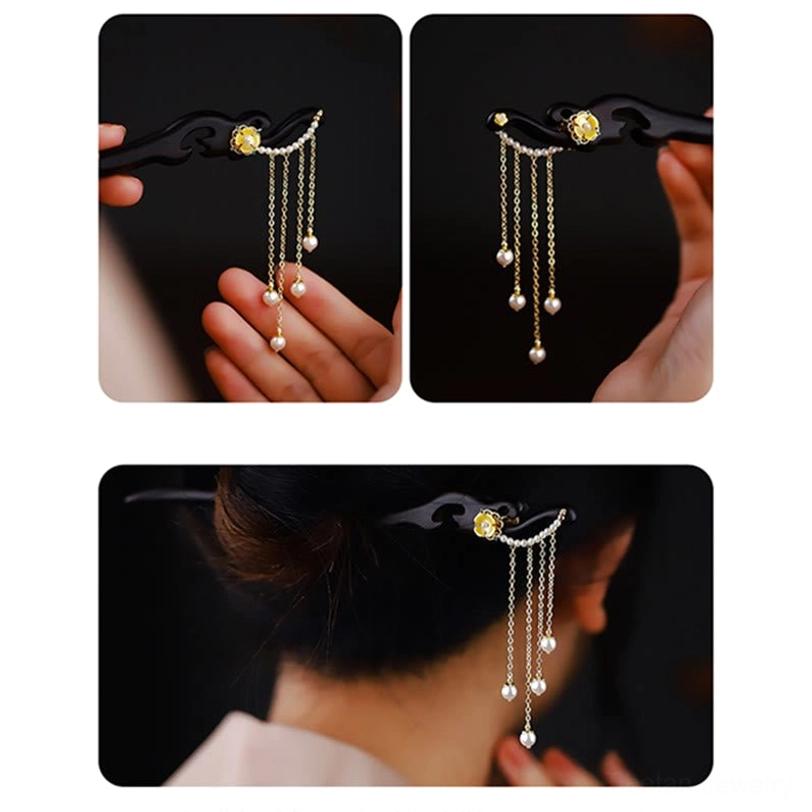 Side hand-held view of ebony wood carving detail with yellow flower motif and pearl tassel decoration