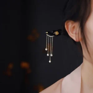 Ebony wood spiritual hairpin styled in low hair bun, worn side view demonstrating secure fit and elegant tassels