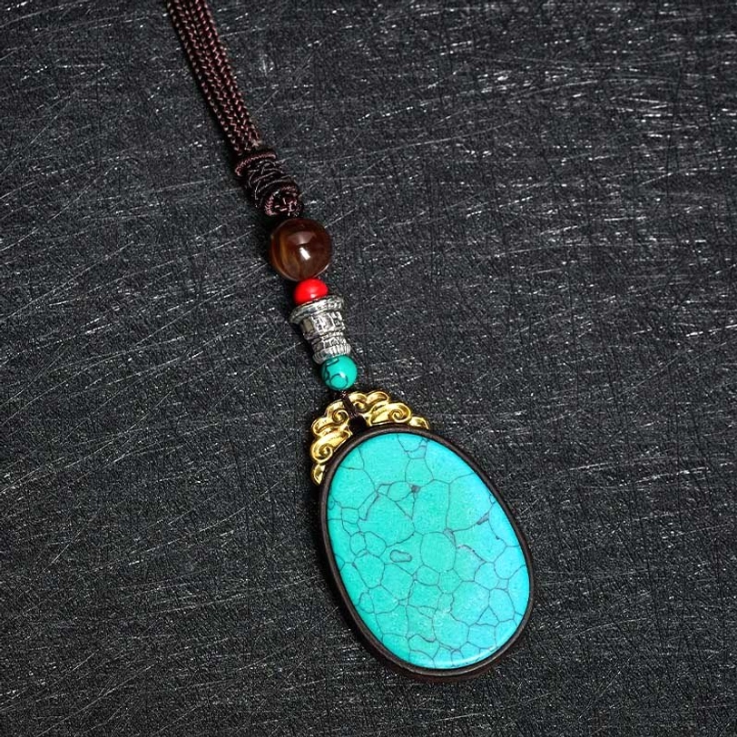 Ebony wood tribal necklace detail shot showing natural grain texture and copper alloy accents