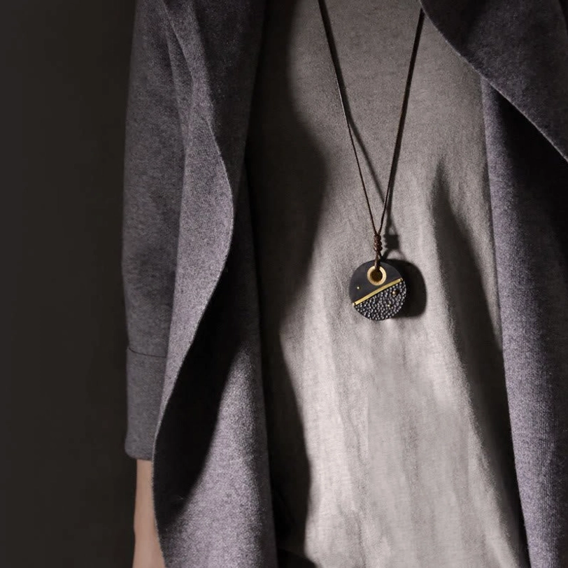Worn ebony wood Tibetan pendant necklace on person showing authentic wearable styling