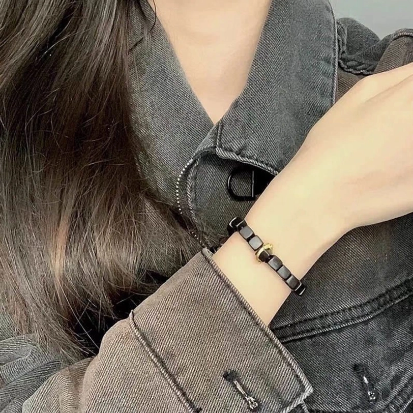 Minimalist ebony wood square bead bracelet with matte finish worn on wrist with denim clothing