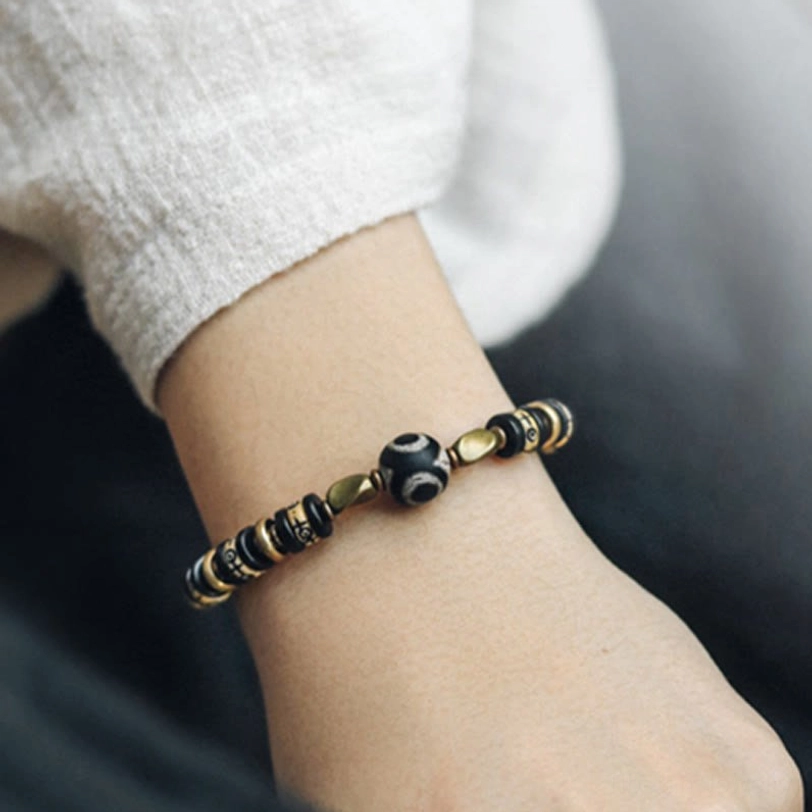 Minimalist ebony wood protection bracelet on wrist with casual outfit