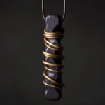 Handcrafted ebony wood Tibetan zen circle pendant with brass wire wrapping, close-up front view showing natural wood grain texture and metal detail