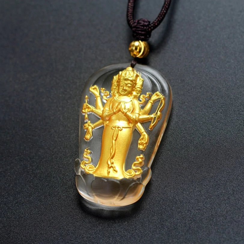 Detailed angled view of Eight-armed Avalokitesvara crystal pendant showing polished clear Liuli glass base with intricate gold Buddhist sculpture and matching necklace
